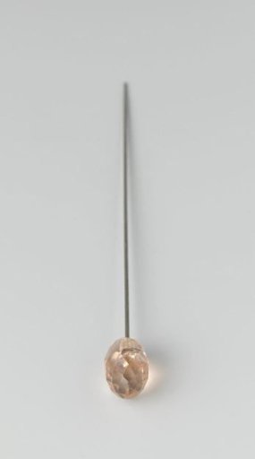 Hatpin of metal with a teardrop-shaped head of pink glass, faceted