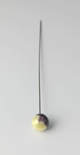 Hatpin of metal with a globe of yellow and purple flamed glass