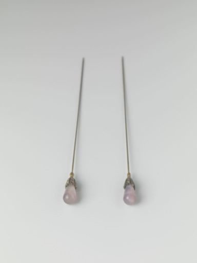 Hatpin of metal with a purple teardrop-shaped glass knob