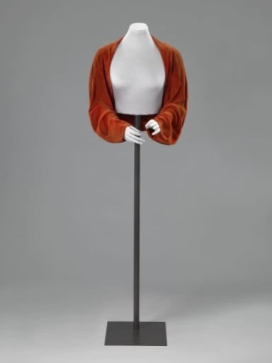 Short, flaring jacket of orange-red silk velvet with long sleeves and without fastening