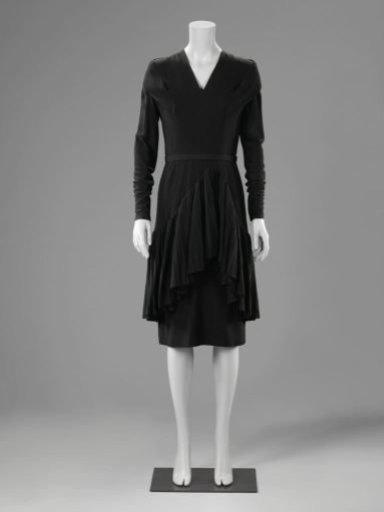 Cocktail jacket of black wool (a) with a wide pleated flounce over the skirt and matching narrow belt (b)
