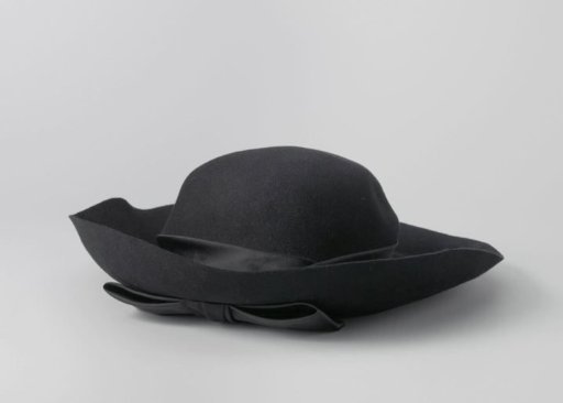 Hat of black felt with satin band around the crown, ending in the front in a flat bow with matching hat pin