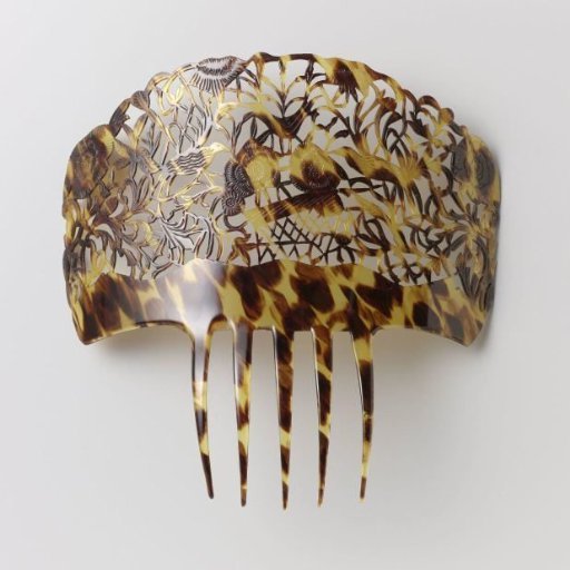 Hair comb of imitation tortoiseshell with a large pierced back carved in relief with flowers, plants, and birds