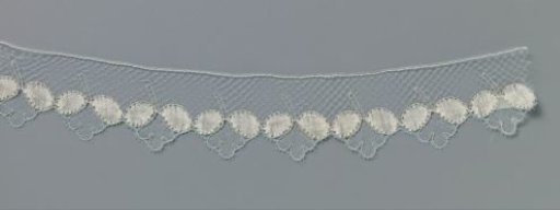 Strip of bobbin lace with hanging three-lobed flower between two oval leaves