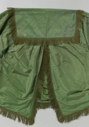 Green cover with green woolen fringe.