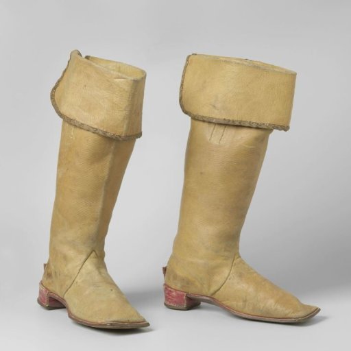 Knee-high boot of yellow cowhide, with a cuff trimmed with gold braid at the top of the shaft
