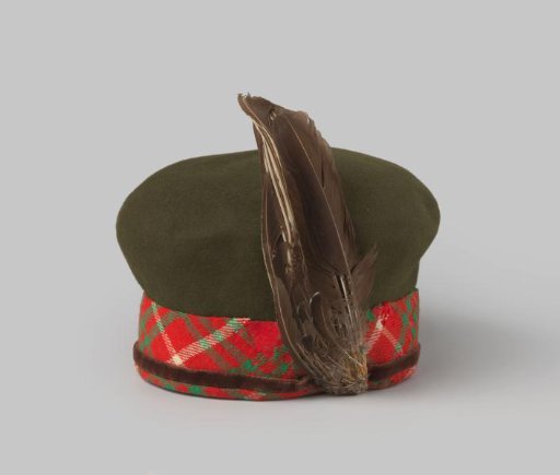 Beret of moss-green felt decorated with a woolen Scottish tartan band and a plume of feathers