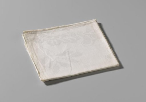 Linen damask napkin with a design of a flower vase surrounded by lacework with a lace pattern