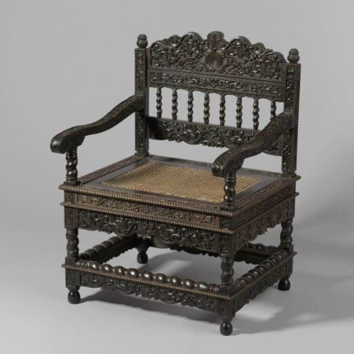 Armchair of tropical wood with a loose seat frame covered in cane; the chair has, among other things, twisted colonettes and is decorated with punched lotus scrolls and rope borders