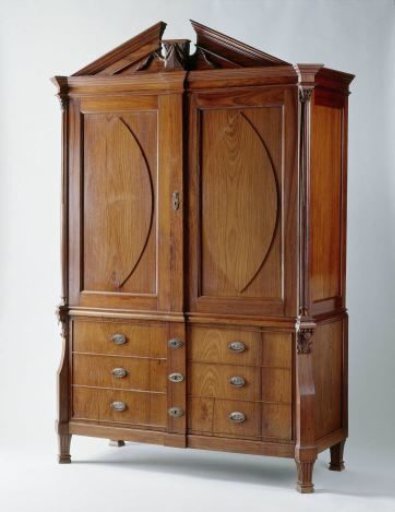 Cabinet of tropical wood with doors inlaid with pointed oval of ebony and above the doors a pediment with a vase and laurel wreath