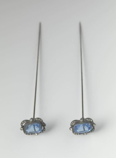Steel hatpin with an elongated ornament of faceted blue glass set in a steel rim with faceted rhinestones