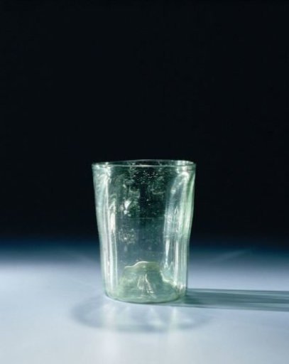 Beaker of clear green glass with many air bubbles and vertical ribs