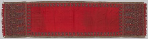 Rectangular Kashmir shawl, with an unadorned red centre, surrounded by a border of loose, half-volutes with flowers and at the ends two large motifs