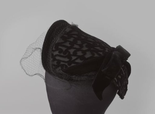 Hat of black velvet with a bow at the back and voile at the front