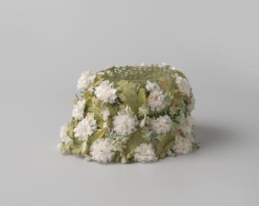 Hat of green netting with carnations and leaves glued on