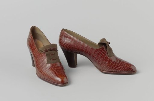 Shoe of red-brown snakeskin with a tongue of brown suede and a laced and tied leather lace