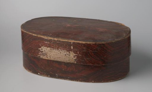 Oval lid of wood, pasted on the outside with imitation wood paper and on the inside with marbled paper