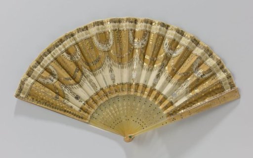 Folding fan with a leaf of beige tulle decorated with ochre silk, steel and copper paillettes and sequins on a mount of golden-yellow plastic inlaid with steel and decorated with gold paint