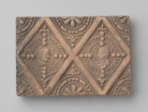 Fireplace surround with a depiction of two facing male busts and a female bust