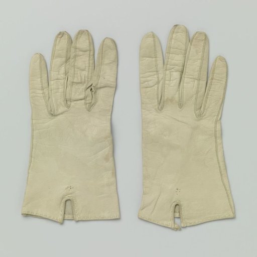 Glove of cream-colored leather with light green running stitch