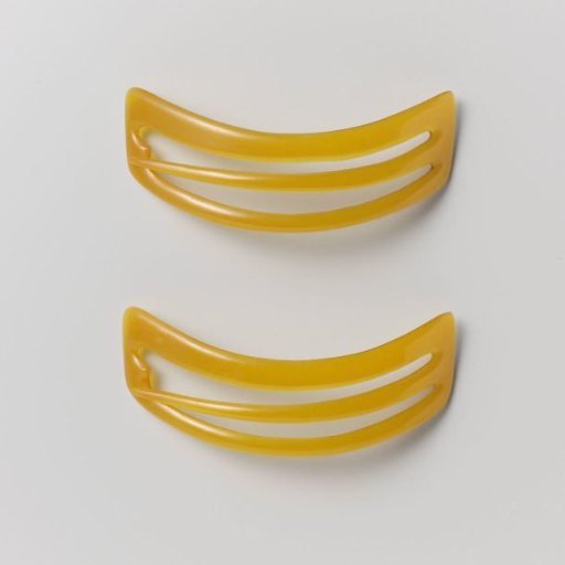 Hairpin of orange-yellow plastic, in curved trapezoid shape