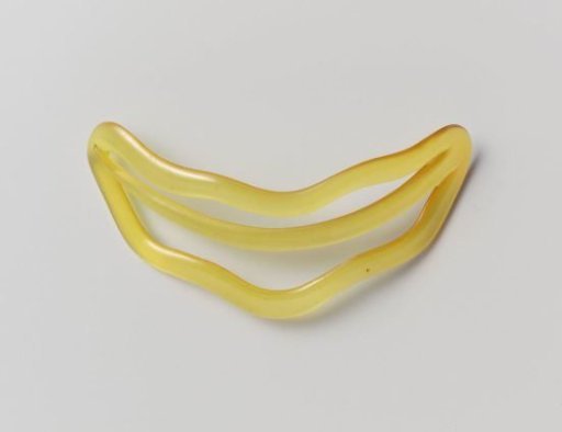 Hairpin of golden-yellow plastic, with wavy edge