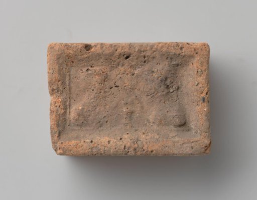 Fireplace with a depiction of a man's and a woman's head in profile, separated by a flowering plant