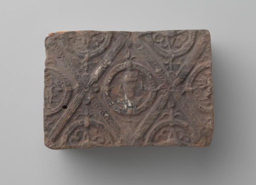 Fireplace with a man's head and the letters V I in a laurel wreath