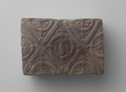 Fireplace with a man's head and the letters V I in a laurel wreath