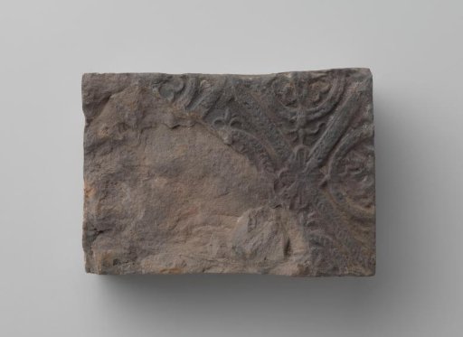 Fireplace with a man's head and the letters V I in a laurel wreath