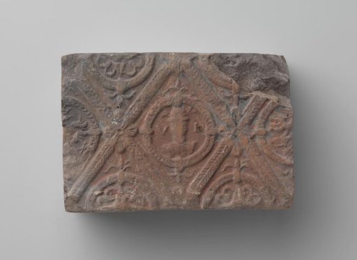 Fireplace with a man's head and the letters V I in a laurel wreath