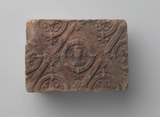 Fireplace with a man's head and the letters V I in a laurel wreath