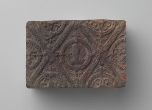 Fireplace with a man's head and the letters V I in a laurel wreath