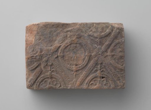 Fireplace mantel with a man's head and the letters V I in a laurel wreath