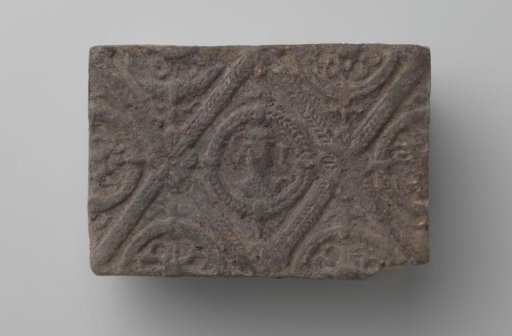 Fireplace with a man's head and the letters V I in a laurel wreath