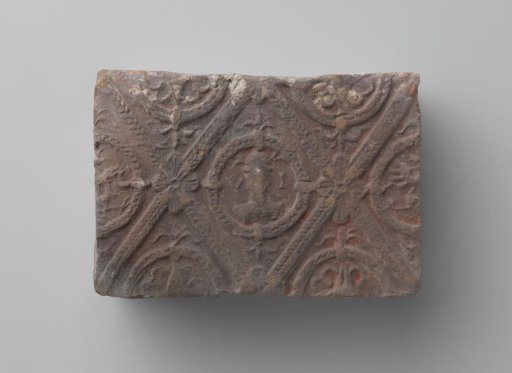 Fireplace with a man's head and the letters V I in a laurel wreath