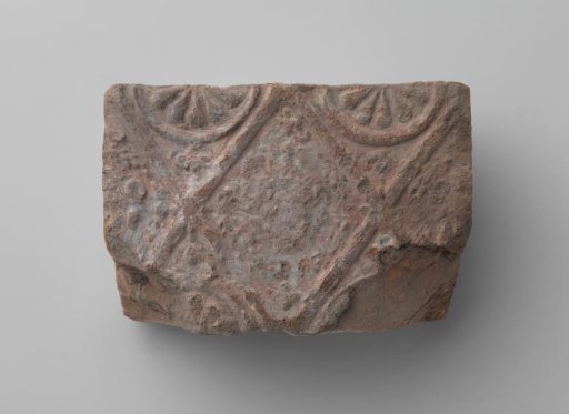 Fireplace surround with a man's head and the letters V I in a laurel wreath