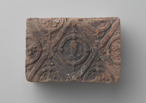 Fireplace surround with a man's head and the letters V I in a laurel wreath
