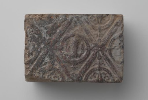 Fireplace surround with a man's head and the letters V I in a laurel wreath