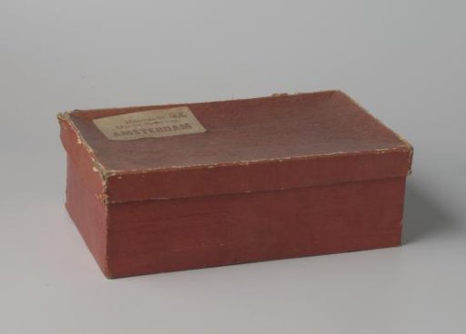 Rectangular cardboard box, covered with red paper; on the loose lid a label reading Hollandsche // IJzeren Spoorweg, // Amsterdam