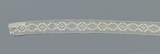 Insert of machine-made lace with a chain of stylized round flowers