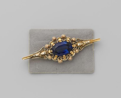 Brooch of gold with an oval blue glass