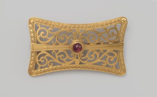 Brooch of openwork gold with a central reddish-purple glass stone