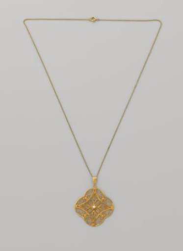 Pendant of filigree in gold with a natural pearl on a necklace