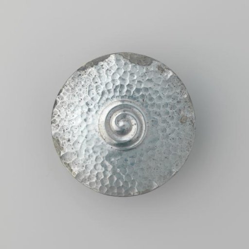 Round plaque of silver-colored base metal