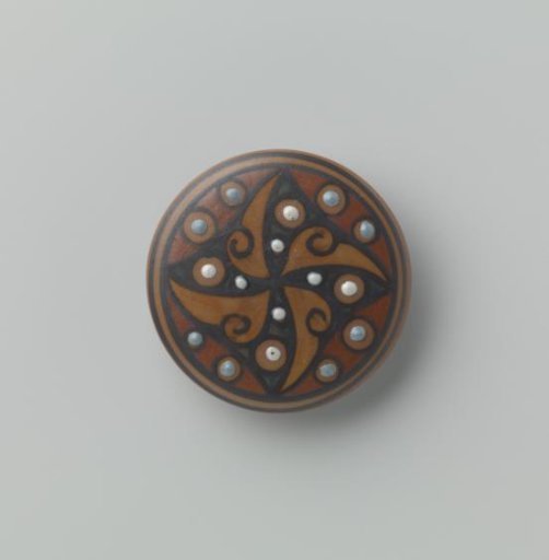 Round brooch in slip decoration in various shades of ochre