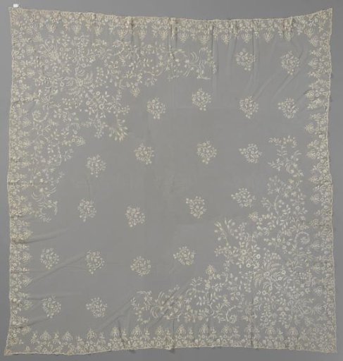 Dress of appliqué lace with symmetrical scrolling foliage in diagonal opposite corners