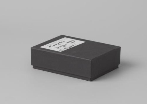 Box of black cardboard with loose lid and black foam rubber