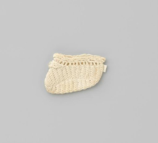 White crocheted sock with a pearl-coloured button