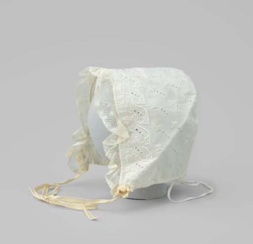 Baby cap of white textile with gathered applied strip of lace with picots